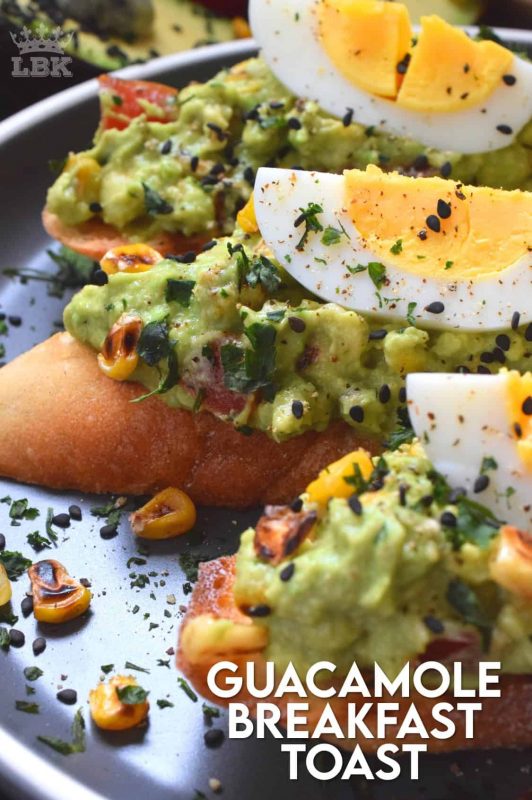 Guacamole Breakfast Toast makes for a full and hearty breakfast. Toasted bread piled with avocado, corn, and tomatoes; topped with wedges of hard boiled egg. A perfectly delicious meal anytime of the day! #avocado #guacamole #breakfast #toast #bread