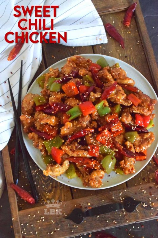 Sweet Chili Chicken is a prepared with a homemade sweet and spicy sauce, and tossed with red and green bell peppers. Use boneless, skinless chicken thighs and finish with toasted sesame seeds for best results. #sweet #heat #chili #sauce #chicken #takeout #asian #fried