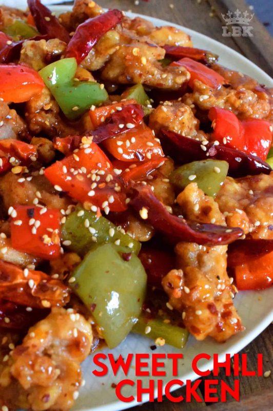 Sweet Chili Chicken is a prepared with a homemade sweet and spicy sauce, and tossed with red and green bell peppers. Use boneless, skinless chicken thighs and finish with toasted sesame seeds for best results. #sweet #heat #chili #sauce #chicken #takeout #asian #fried