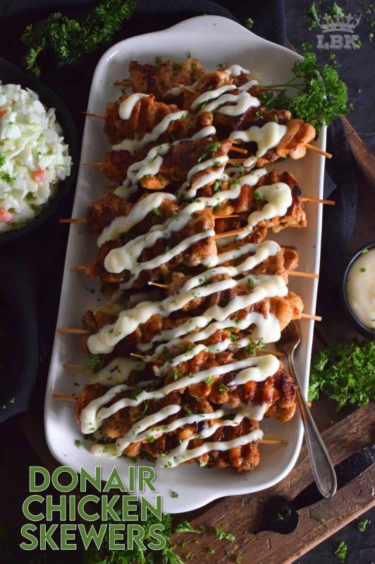 Donair Chicken Skewers are prepared with marinated chicken thighs in a make-at-home Greek seasoning blend, and then grilled to perfection.  Topped with a homemade donair sauce, these skewers will be an immediate new family favourite! #donair #chicken #skewers #grilled #sauce #foodonsticks