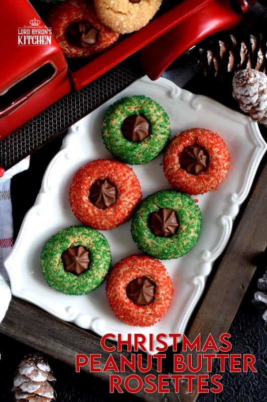 A light and fluffy peanut butter cookie with a milk chocolate rosette center, which has been rolled in sanding sugar. Christmas Peanut Butter Rosettes will add lots of festive colour and flavour to your holiday baking. These are a great addition to a cookie exchange! #christmas #holiday #baking #peanutbutter #rosette #chocolate #cookies