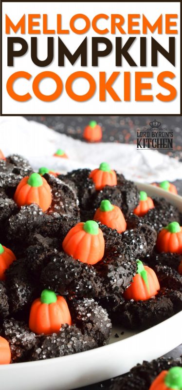 These festive cookies are deliciously decadent. The base is a chocolate cookie that has been darkened to resemble the blackness that goes hand in hand with Halloween. Before baking, the cookie is rolled in black sanding sugar which adds a glistening effect. Finally, a Mellocreme Pumpkin is pushed into the center to make these one of the most adorable Halloween cookies! #halloween #mellocreme #pumpkin #cookies #candy #candycorn