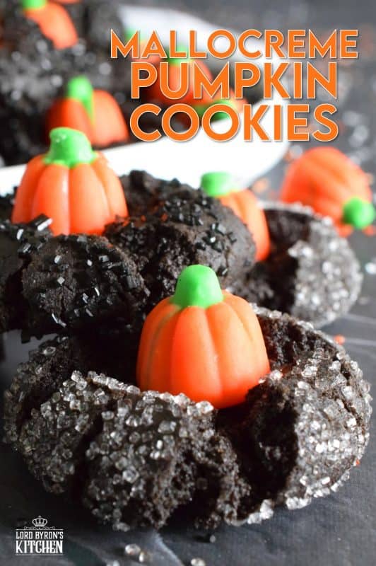 These festive cookies are deliciously decadent. The base is a chocolate cookie that has been darkened to resemble the blackness that goes hand in hand with Halloween. Before baking, the cookie is rolled in black sanding sugar which adds a glistening effect. Finally, a Mellocreme Pumpkin is pushed into the center to make these one of the most adorable Halloween cookies! #halloween #mellocreme #pumpkin #cookies #candy #candycorn