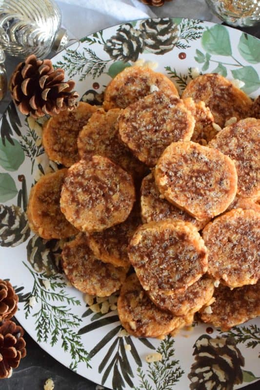 Caramel Peanut Slices are a no-bake confection consisting of caramel, peanut butter, rice krispies cereal, chocolate, and chopped peanuts. Working in layers, it is rolled into a log and chilled until set. The log is cut into slices before being served. These cookies are irresistible and one of my all-time favourite Christmas treats! #caramel #caramellogs #christmas #holiday #nobake #cookies #peanutbutter