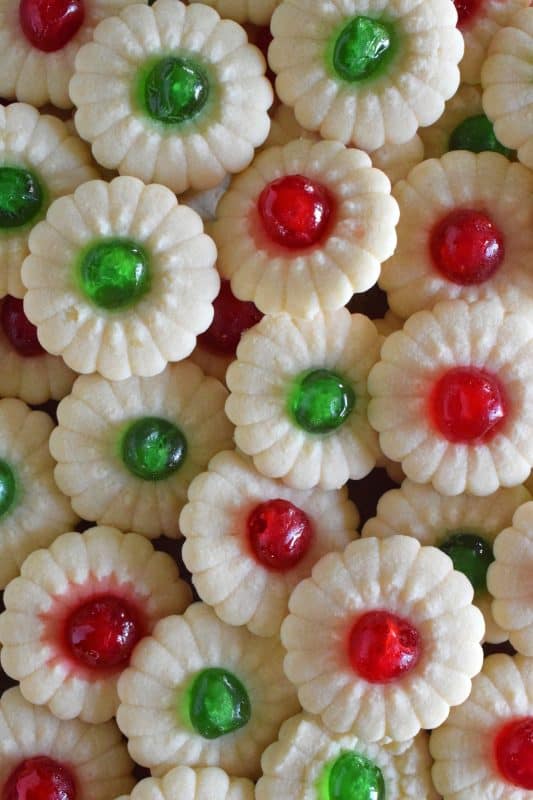 A good spritz cookie should taste slightly sweet and buttery. The cookie should be slightly crumbly, but not dry, and it should melt on your tongue. Nothing is more Christmassy than Cherry Spritz Cookies! It's a long-standing holiday favourite and this one screams cheerful with those brightly coloured candied cherries! #candiedcherries #spritz #spritzcookies #baking #christmas #holiday #redandgreen