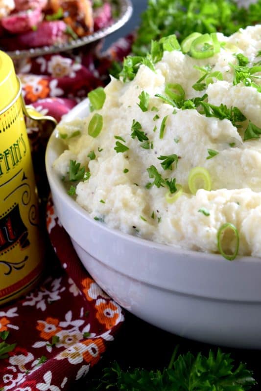 A mashed potato substitute that's health conscious and free of butter and heavy cream. Cheesy Mashed Cauliflower is creamy, flavourful, and delicious without all of the calories and extra fat. The addition of fresh green onions adds a crisp, refreshing taste. #cauliflower #creamcheese #mashedcauliflower #potatoalternative #mashed #thanksgiving #sidedish