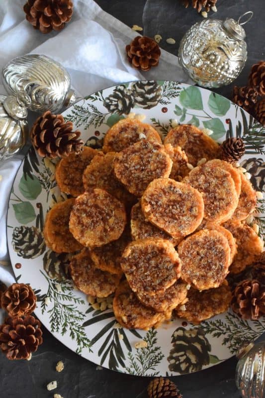 Caramel Peanut Slices are a no-bake confection consisting of caramel, peanut butter, rice krispies cereal, chocolate, and chopped peanuts. Working in layers, it is rolled into a log and chilled until set. The log is cut into slices before being served. These cookies are irresistible and one of my all-time favourite Christmas treats! #caramel #caramellogs #christmas #holiday #nobake #cookies #peanutbutter