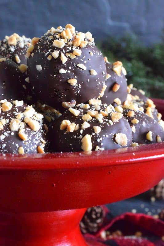 Dipped in melted milk chocolate and topped with chopped, salted peanuts, Crispy Peanut Butter Truffles are a delicious confection that not only melts in your mouth, but the inside has an airy and crispy bite from the Rice Krispies Cereal, peanuts, and chocolate chips. This truffle is for the serious peanut butter and chocolate lover! #christmas #holiday #nobake #truffles #peanutbutter #chocolate #ricekrispies