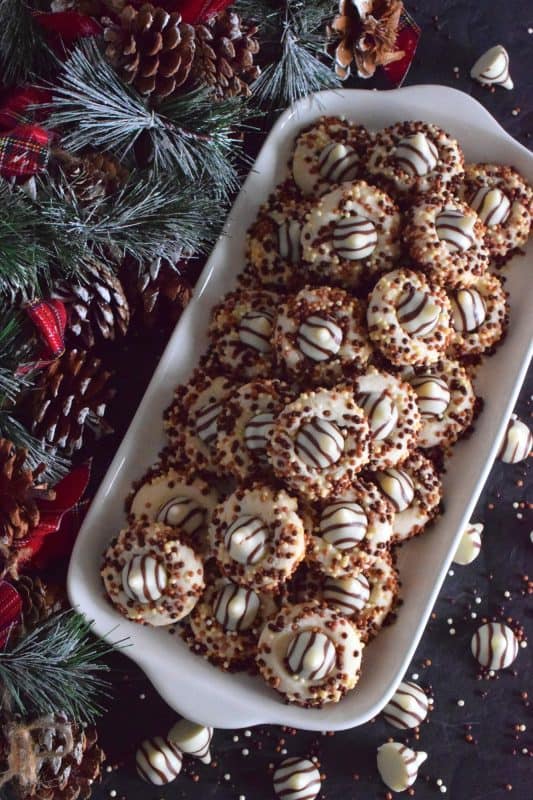 Christmastime is rushed and hurried, especially for the home cook, which leaves little time or desire for cookies that require chilled dough and rolling pins. Hershey Blossom Cookies are made with a whipped shortbread dough, rolled in sprinkles and dotted with a chocolate kiss. They're simple, beautiful, and delicious! Also, they're ready to eat in less than 30 minutes! #hershey #chocolatekiss #kiss #cookies #christmas #holiday #baking