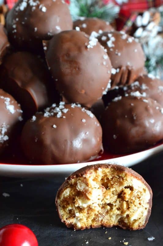 This is a cookie that has been baked into a ball and then dipped into melted chocolate and topped with flaked sea salt. If you love the combination of salty and sweet, than Pretzel Chocolate Cookies are for you! #christmas #holiday #baking #cookie #balls #chocolate #pretzels #cookieexchange