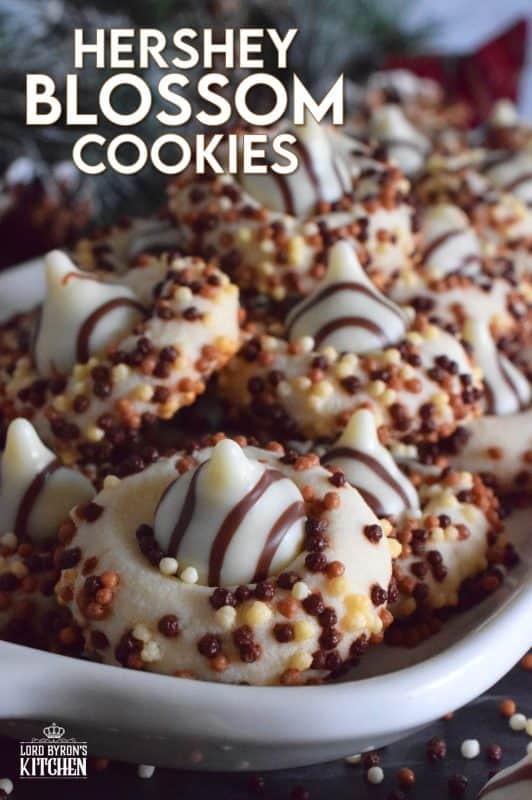 Christmastime is rushed and hurried, especially for the home cook, which leaves little time or desire for cookies that require chilled dough and rolling pins. Hershey Blossom Cookies are made with a whipped shortbread dough, rolled in sprinkles and dotted with a chocolate kiss. They're simple, beautiful, and delicious! Also, they're ready to eat in less than 30 minutes! #hershey #chocolatekiss #kiss #cookies #christmas #holiday #baking