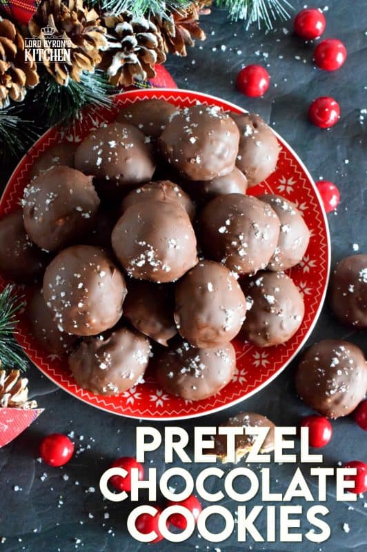 This is a cookie that has been baked into a ball and then dipped into melted chocolate and topped with flaked sea salt. If you love the combination of salty and sweet, than Pretzel Chocolate Cookies are for you! #christmas #holiday #baking #cookie #balls #chocolate #pretzels #cookieexchange