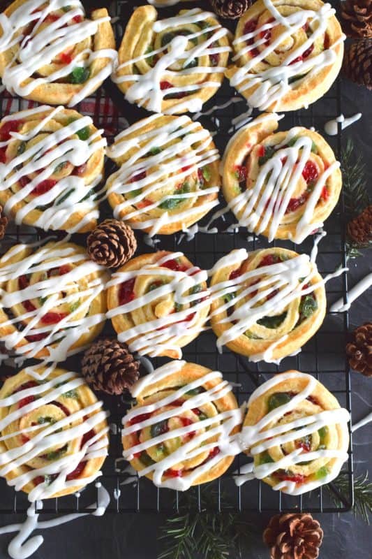 One of my favourite Christmas ingredients is being put to great use today! Cherry Pinwheel Cookies are made with a light, biscuit-like dough and rolled with red and green candied cherries. Drizzled with a basic sweet icing, these are absolutely delicious and very festive too! #christmas #holiday #baking #cherries #candiedcherries #cherry #redandgreen #drizzle