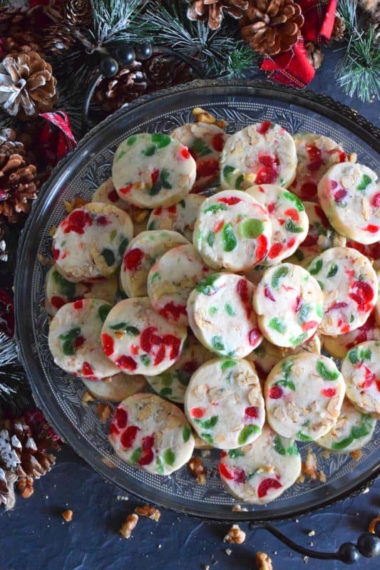 Chopped red and green candied cherries add a pop of festive colour and delicious flavour to these Walnut Cherry Slices. Prepare a month in advance and freeze the dough. When ready to bake, simply cut the dough into slices and bake until light and fluffy. These cookies are perfect for a cookie exchange or for gifting to a neighbour! #shortbread #candiedcherries #cherries #christmas #holiday #baking #sliceandbake