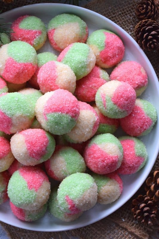 Holiday Neopolitan Cookies are two-bite cookies made with red, green, and white cookie dough. They are rolled in sugar and baked for a cute and festive Christmas confection. Use different extracts in each dough colour or prepare them with just good vanilla! #neopolitan #christmas #holiday #cookies #redandgreen