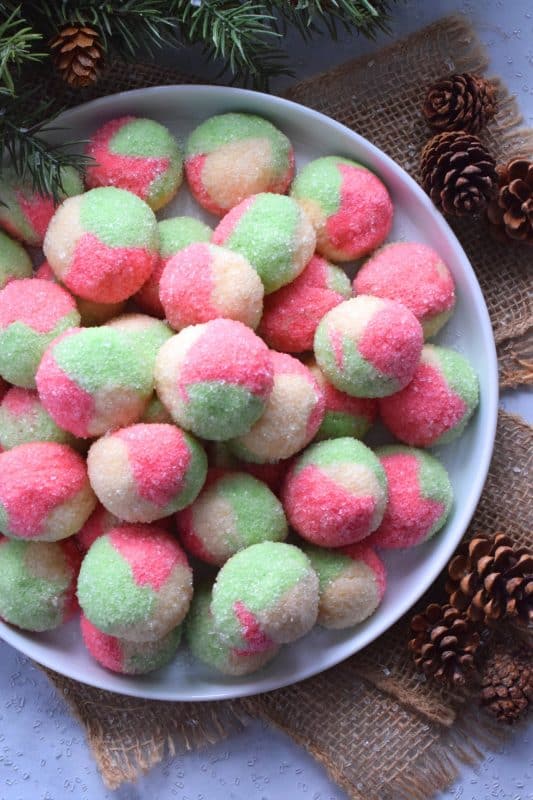 Holiday Neopolitan Cookies are two-bite cookies made with red, green, and white cookie dough. They are rolled in sugar and baked for a cute and festive Christmas confection. Use different extracts in each dough colour or prepare them with just good vanilla! #neopolitan #christmas #holiday #cookies #redandgreen