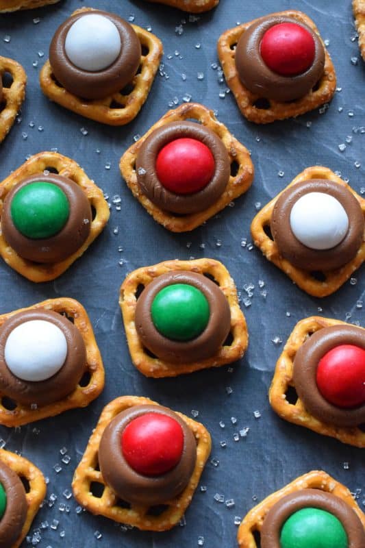 With only three ingredients, M&M Pretzel Treats are one of those no-bake confections that can be made in just a few minutes. It requires very little clean up, and you can change up the colours and flavours quite easily. Be sure to add these to your Christmas Eve treat table! #nobake #treats #M&M #christmas #holiday #chocolate #pretzels