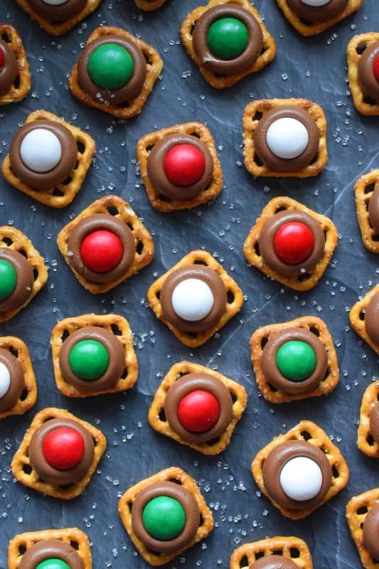 With only three ingredients, M&M Pretzel Treats are one of those no-bake confections that can be made in just a few minutes. It requires very little clean up, and you can change up the colours and flavours quite easily. Be sure to add these to your Christmas Eve treat table! #nobake #treats #M&M #christmas #holiday #chocolate #pretzels