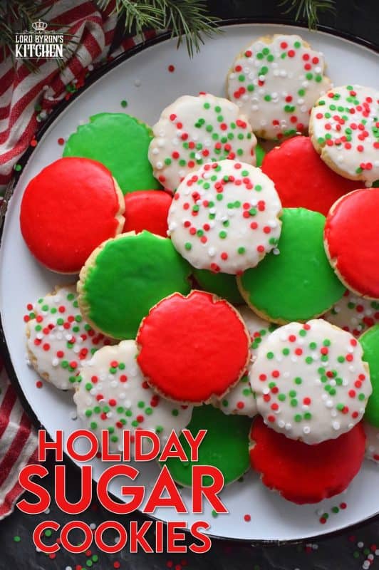 This recipe consists of a melt-in-your-mouth sugar cookie base, topped with a thin, sugary glaze, and festive sprinkles. Holiday Sugar Cookies are brightly and vividly coloured with red and green frosting and will appeal to both the little kids and the big kids in your life! #christmas #holiday #baking #sugarcookies #cookies