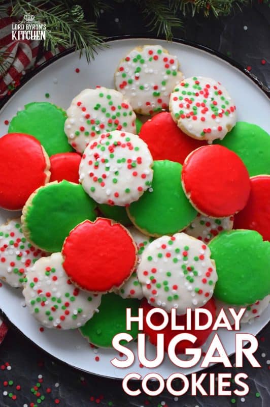 This recipe consists of a melt-in-your-mouth sugar cookie base, topped with a thin, sugary glaze, and festive sprinkles. Holiday Sugar Cookies are brightly and vividly coloured with red and green frosting and will appeal to both the little kids and the big kids in your life! #christmas #holiday #baking #sugarcookies #cookies