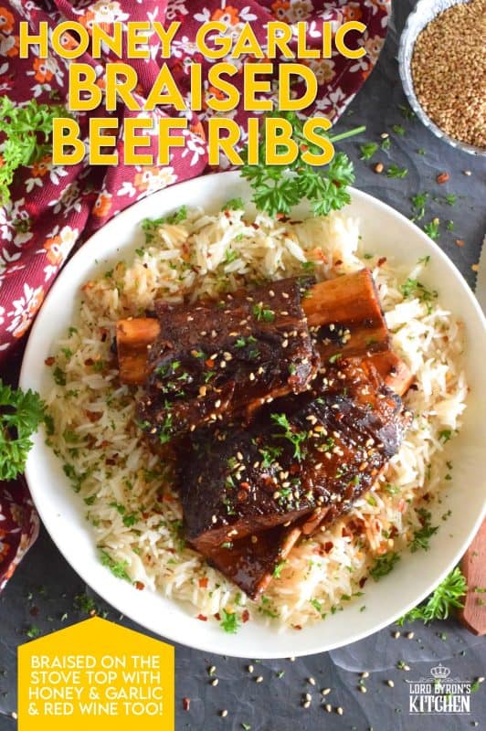 Pan-seared beef ribs are braised in a honey garlic sauce prepared with red wine. These moist and tender ribs are perfect for a cold winter night's dinner. Serve with hearty polenta or mashed potatoes and be sure to ladle on some of that thick, glossy, sweet, and garlicky sauce! #beef #beefribs #shortribs #honeygarlic #dutchoven #braised