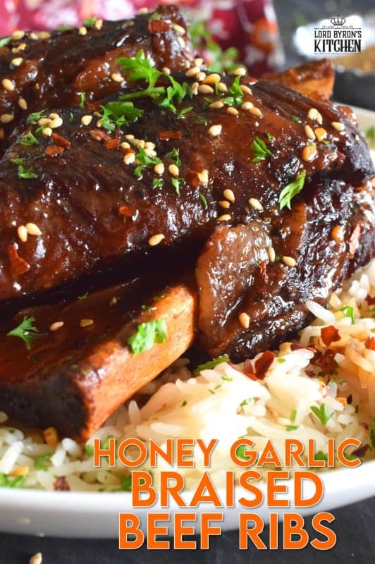 Pan-seared beef ribs are braised in a honey garlic sauce prepared with red wine. These moist and tender ribs are perfect for a cold winter night's dinner. Serve with hearty polenta or mashed potatoes and be sure to ladle on some of that thick, glossy, sweet, and garlicky sauce! #beef #beefribs #shortribs #honeygarlic #dutchoven #braised