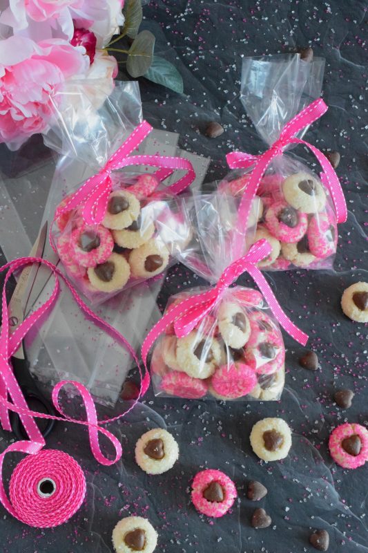 These adorable bite-sized cookies are bound to be a complete hit! They look stunning all on their own, but are perfect for gift giving to your favourite valentine! Valentine Heart Cookies are prepared with a basic butter and sugar cookie, rolled in pink sugar, and topped with a chocolate heart! #valentine #cookies #pinkrecipes #valentinerecipes