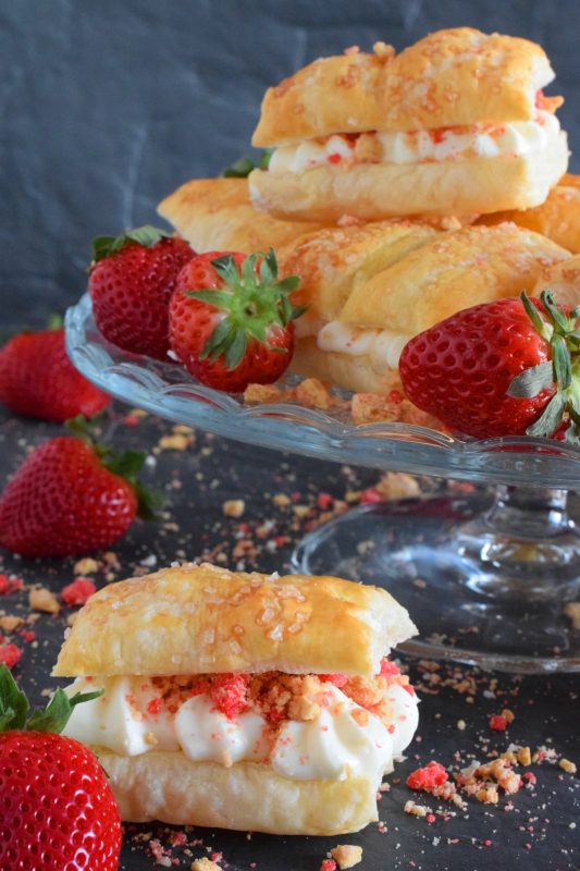 A deliciously creamy and sweet frosting is layered between a flaky and crispy puff pastry with strawberry shortcake crumbs and homemade strawberry jam. Copycat Strawberry Shortcake Flakies just might be better than the original store-bought version! Give them a try! #flakies #passionflakies #copycatrecipes #strawberryshortcake #strawberry #valentine #desserts