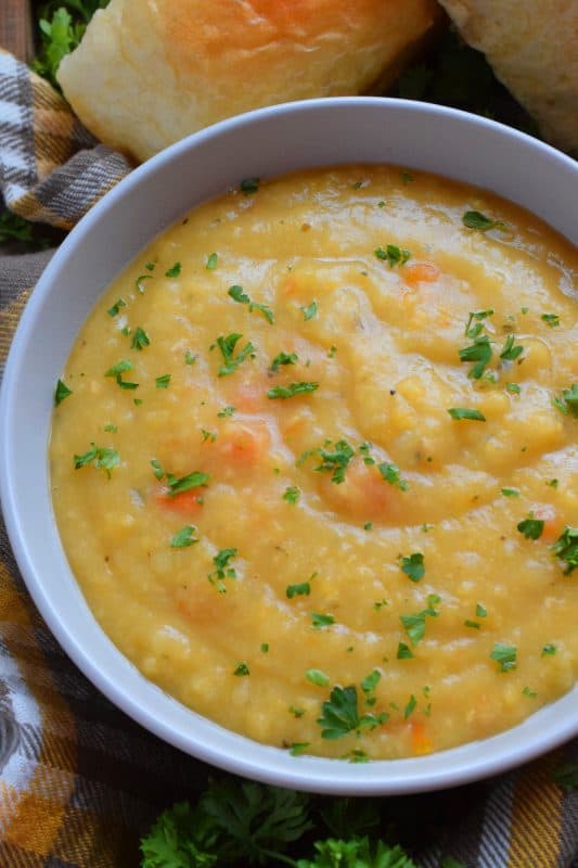 Vegetarian Split Pea Soup is every bit as delicious, wholesome, and nostalgic as the soup your mom made. This is a pantry staple recipe with a few fresh root vegetables. Not looking for vegetarian soup? Add bacon or ham to your soup or serve them both on the side! #soup #splitpea #split #pea #dried #yellow #dumplings #vegetarian