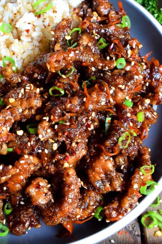 Thinly sliced beef, fried until crispy, and coated in a sweet and slightly spicy garlic and ginger sauce; 30 Minute Ginger Beef is an inexpensive dinner the whole family will love! #ginger #beef #takeout #homemade #garlic #fried #crispy