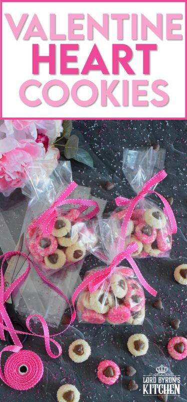These adorable bite-sized cookies are bound to be a complete hit! They look stunning all on their own, but are perfect for gift giving to your favourite valentine! Valentine Heart Cookies are prepared with a basic butter and sugar cookie, rolled in pink sugar, and topped with a chocolate heart! #valentine #cookies #pinkrecipes #valentinerecipes