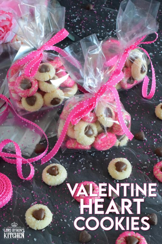 These adorable bite-sized cookies are bound to be a complete hit! They look stunning all on their own, but are perfect for gift giving to your favourite valentine! Valentine Heart Cookies are prepared with a basic butter and sugar cookie, rolled in pink sugar, and topped with a chocolate heart! #valentine #cookies #pinkrecipes #valentinerecipes