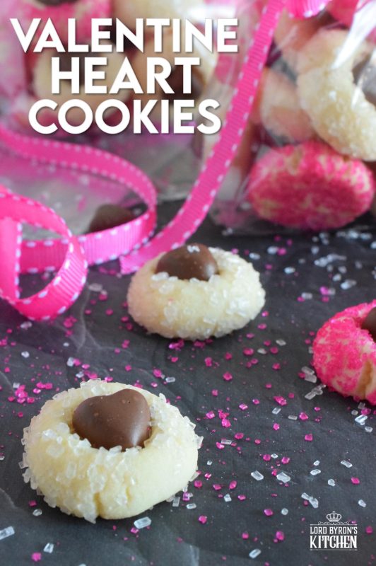 These adorable bite-sized cookies are bound to be a complete hit! They look stunning all on their own, but are perfect for gift giving to your favourite valentine! Valentine Heart Cookies are prepared with a basic butter and sugar cookie, rolled in pink sugar, and topped with a chocolate heart! #valentine #cookies #pinkrecipes #valentinerecipes
