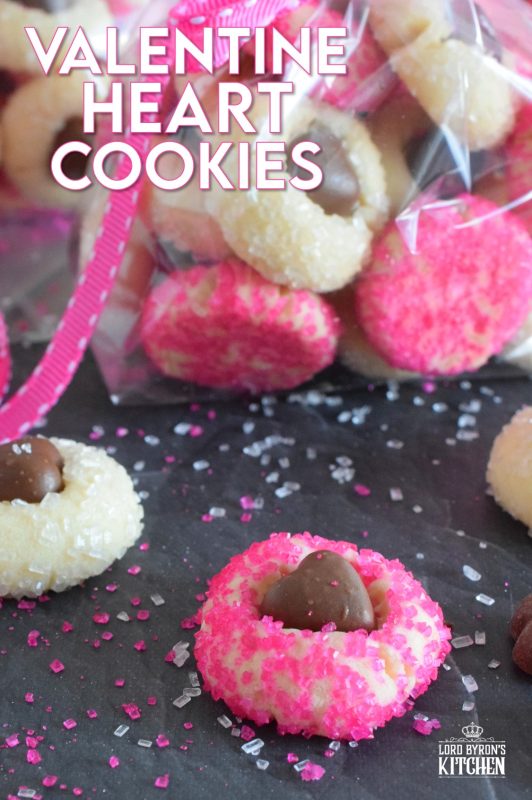 These adorable bite-sized cookies are bound to be a complete hit! They look stunning all on their own, but are perfect for gift giving to your favourite valentine! Valentine Heart Cookies are prepared with a basic butter and sugar cookie, rolled in pink sugar, and topped with a chocolate heart! #valentine #cookies #pinkrecipes #valentinerecipes
