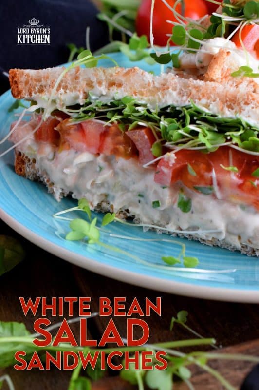 When you mash canned white beans, and combine them with mayo and seasonings, the result is a creamy and tasty vegetarian salad sandwich spread. Top that sandwich with sliced tomatoes, fresh microgreens, and watercress for a very healthy and hearty lunch. #canned #beans #smashed #salad #sandwich #vegetarian #meatless