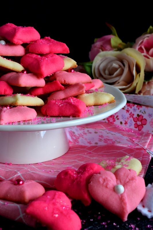 Valentine Spritz Cookies are bright, cheerful, and will bring a smile to anyone's face. These are so easy to make and so delicious too! Break out your sprinkles and have some fun!! #valentinebaking #valentinecookies #pinkrecipes #spritzcookies #cookies #valentinetreats