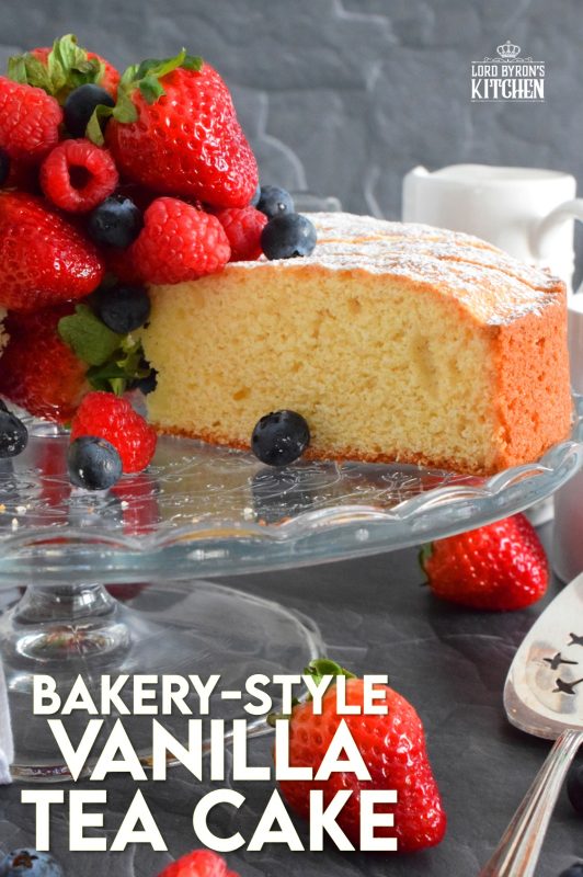 This Bakery Style Vanilla Tea Cake looks superb gussied up with a dusting of confectioner's sugar and a pile of fresh berries. A delightful treat anytime, this cake is the epitome of a beautiful, yet simple, summertime dessert! Bake, slice, and serve with ice cream or whipped cream! #vanillacake #teacake #teatime #bakery