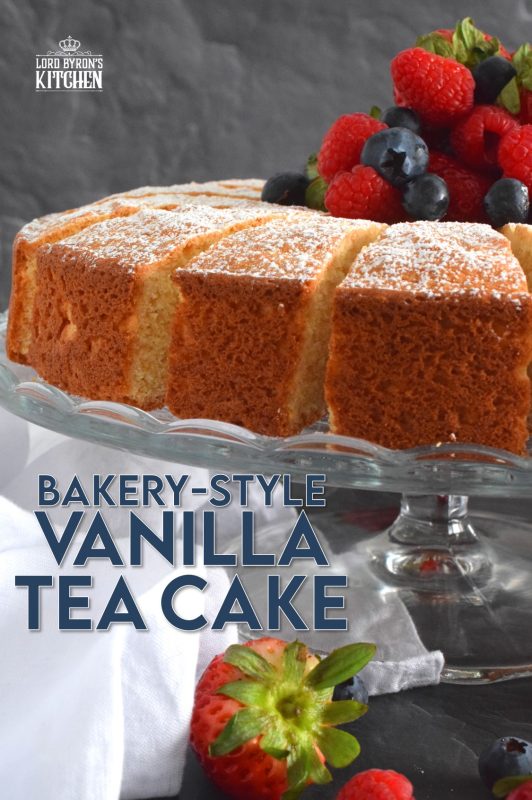 This Bakery Style Vanilla Tea Cake looks superb gussied up with a dusting of confectioner's sugar and a pile of fresh berries. A delightful treat anytime, this cake is the epitome of a beautiful, yet simple, summertime dessert! Bake, slice, and serve with ice cream or whipped cream! #vanillacake #teacake #teatime #bakery