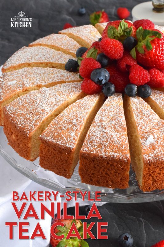 This Bakery Style Vanilla Tea Cake looks superb gussied up with a dusting of confectioner's sugar and a pile of fresh berries. A delightful treat anytime, this cake is the epitome of a beautiful, yet simple, summertime dessert! Bake, slice, and serve with ice cream or whipped cream! #vanillacake #teacake #teatime #bakery