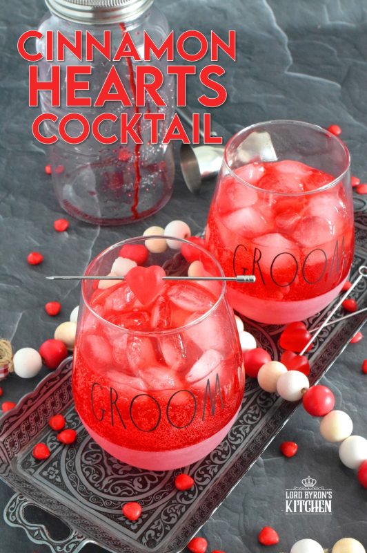 This slightly spicy cocktail is vibrantly red and perfect to share with that special someone on Valentine's Day! Prepared with a homemade, easy-to-make simple syrup made with candy hearts, a good splash of vodka, and club soda, this cocktail is bubbly and has a cozy, warm flavour! #valentines #cocktail #cinnamonhearts #redhots #valentinesday