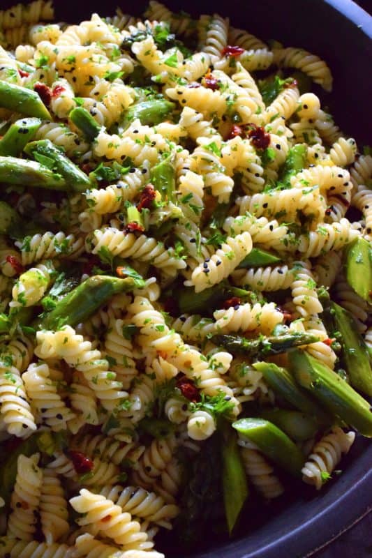 A dish that can only be described as springtime in a bowl, this simple butter roasted asparagus pasta salad, tossed with sun dried tomatoes, fresh lemon, and parmesan. A delightful cold pasta salad that everyone will love! #asparagus #lemon #butter #pasta #salad