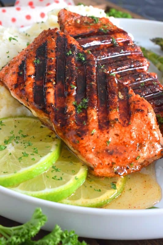 Salmon fillets are liberally dusted with an easy to make homemade blackening seasoning and grilled over high heat to get those prominent grill marks. Once plated, the salmon is drizzled with an optional spiced honey lime sauce. Simple and easy, yet gorgeous and delicious, this is not your average salmon dinner! #blackened #salmon #grilledsalmon #grillingrecipes #30minutemeals