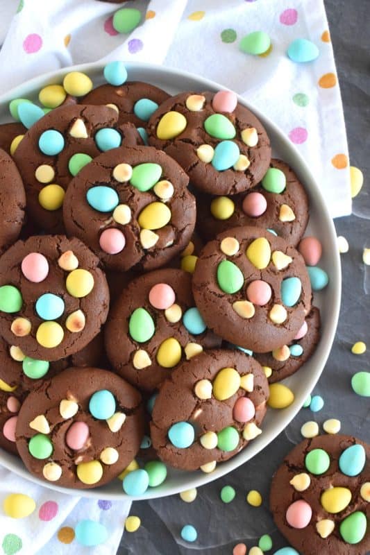 Cadbury Chocolate Cookies are slightly crispy on the outside, with a moist and dense chocolaty center. Stuffed with white chocolate chips and topped with chocolate mini eggs, these are substantial cookies, meaning that they are thick and filling. Great for dunking in a glass of cold milk too! #cadbury #minieggs #easter #cookies #chocolate