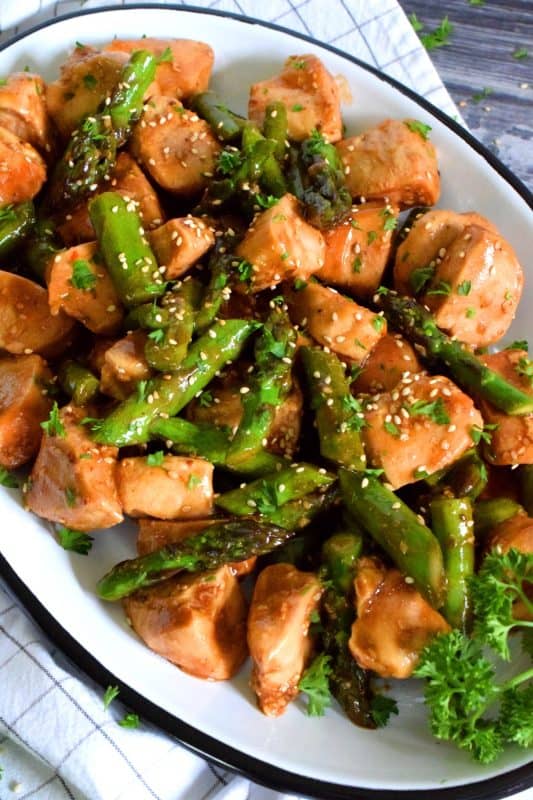 Seasoned boneless and skinless chicken breast pieces are pan-fried with fresh asparagus and in a quick, homemade teriyaki sauce. This is a healthy dinner that is both easy and delicious! #asparagus #chicken #teriyaki #sauce #stirfry #skillet #breasts