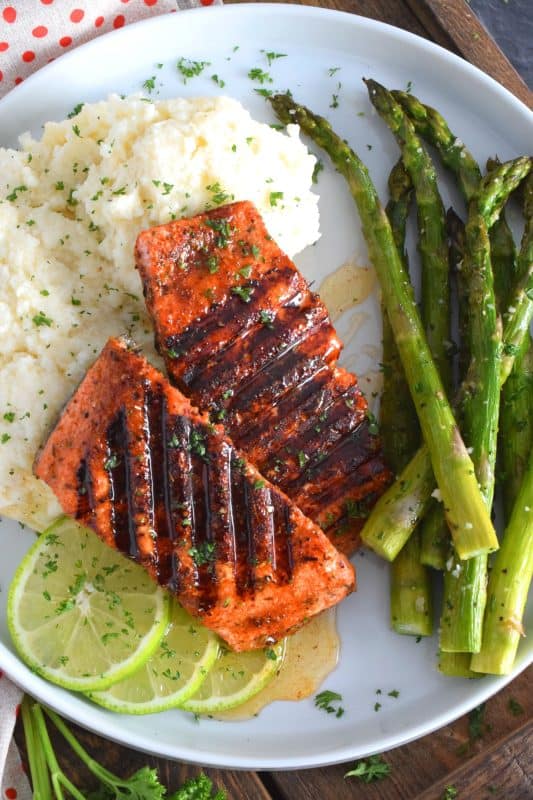 Salmon fillets are liberally dusted with an easy to make homemade blackening seasoning and grilled over high heat to get those prominent grill marks. Once plated, the salmon is drizzled with an optional spiced honey lime sauce. Simple and easy, yet gorgeous and delicious, this is not your average salmon dinner! #blackened #salmon #grilledsalmon #grillingrecipes #30minutemeals
