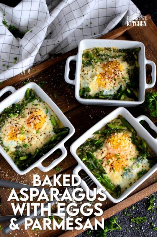 Simple, hearty, and delicious; individual portions make these Baked Asparagus with Eggs and Parmesan easy to serve and a little elegant too! This is exactly how I serve asparagus as a main! Dip some crusty bread in the soft yolks - it's scrumptious!! #baked #asparagus #egg #parmesan #brunch
