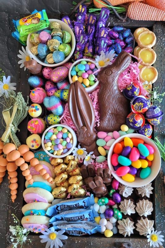 Gather together all of your Easter basket goodies and assemble an Easter Charcuterie Board for your friends and family. It's such an easy way to serve up dessert after dinner, because everything is ready to go, and there's no mess or fuss. All you need is a bunch of napkins and cups of hot coffee for everyone because coffee and chocolate cannot be beat! #charcuterie #easterchocolate #easter #eastercharcuterie #chocolate #bunnies