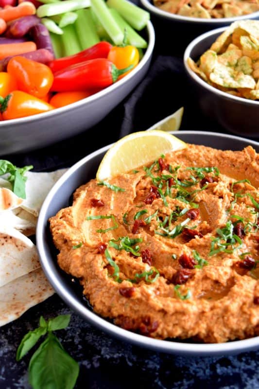 Homemade hummus is always best and it's easy too! All you need is a few basic ingredients to make this delicious Sun Dried Tomato and Fresh Basil Hummus. This one is savoury and slightly salty. And, the brightness from the fresh lemon juice is stellar! You'll never buy prepared hummus again! #hummus #dip #sundriedtomato #basil