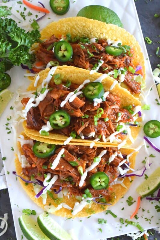 Moist and tender pork shoulder roast is braised in a rich and sweet tomato-based sauce with white wine, and brown sugar. The secret to these absolutely delicious Braised Pulled Pork Tacos is allowing the meat to cook slowly over low heat in a covered pan for multiple hours. Braising cannot be rushed and patience is greatly rewarded with just one bite of this deliciously savoury taco! #tacos #pulledpork #stovetop #castironcooking #dutchoven #porkshoulder #pork