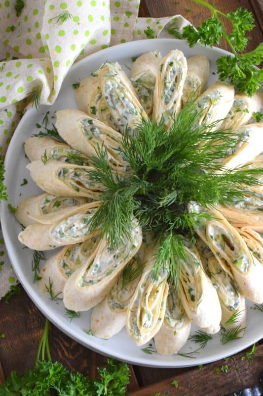 Little sandwiches made with tortillas are often called pinwheels and they are very popular! Not only are they easy to make and quite delicious too, but they are adaptable to any occasion and are enjoyed by kids and adults alike! This particular pinwheel is stuffed with a slightly sweetened cream cheese and chopped cucumber mixture with loads of fresh dill - these just scream spring! #pinwheels #cucumber #dill #appetizers #fingerfoods